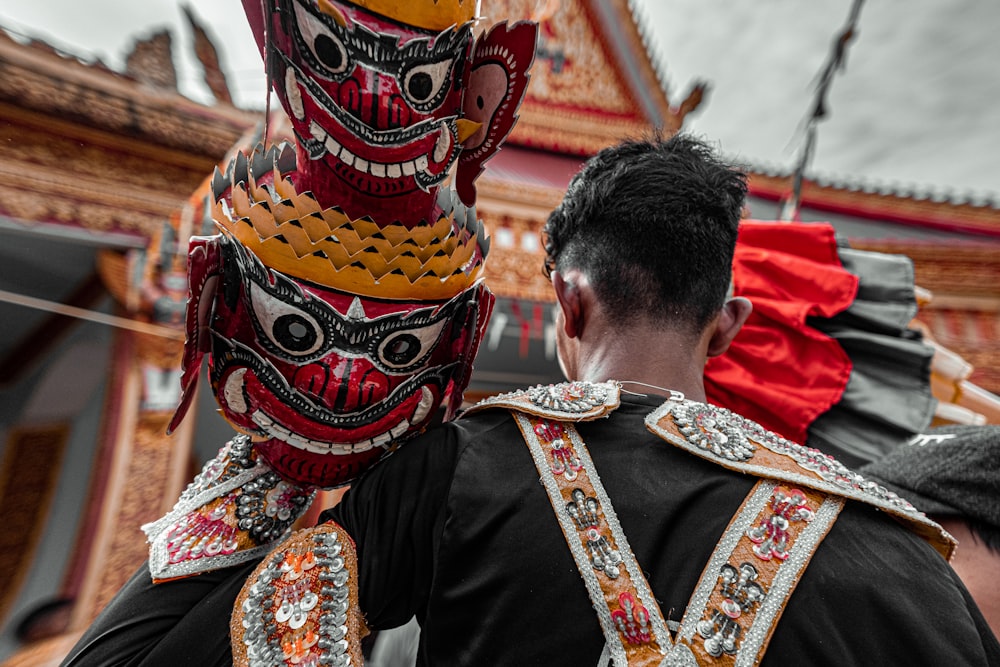 man in black shirt wearing red and yellow mask