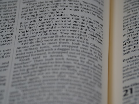 A close-up of an open Bible with a flickering flame beside it, symbolizing divine inspiration.