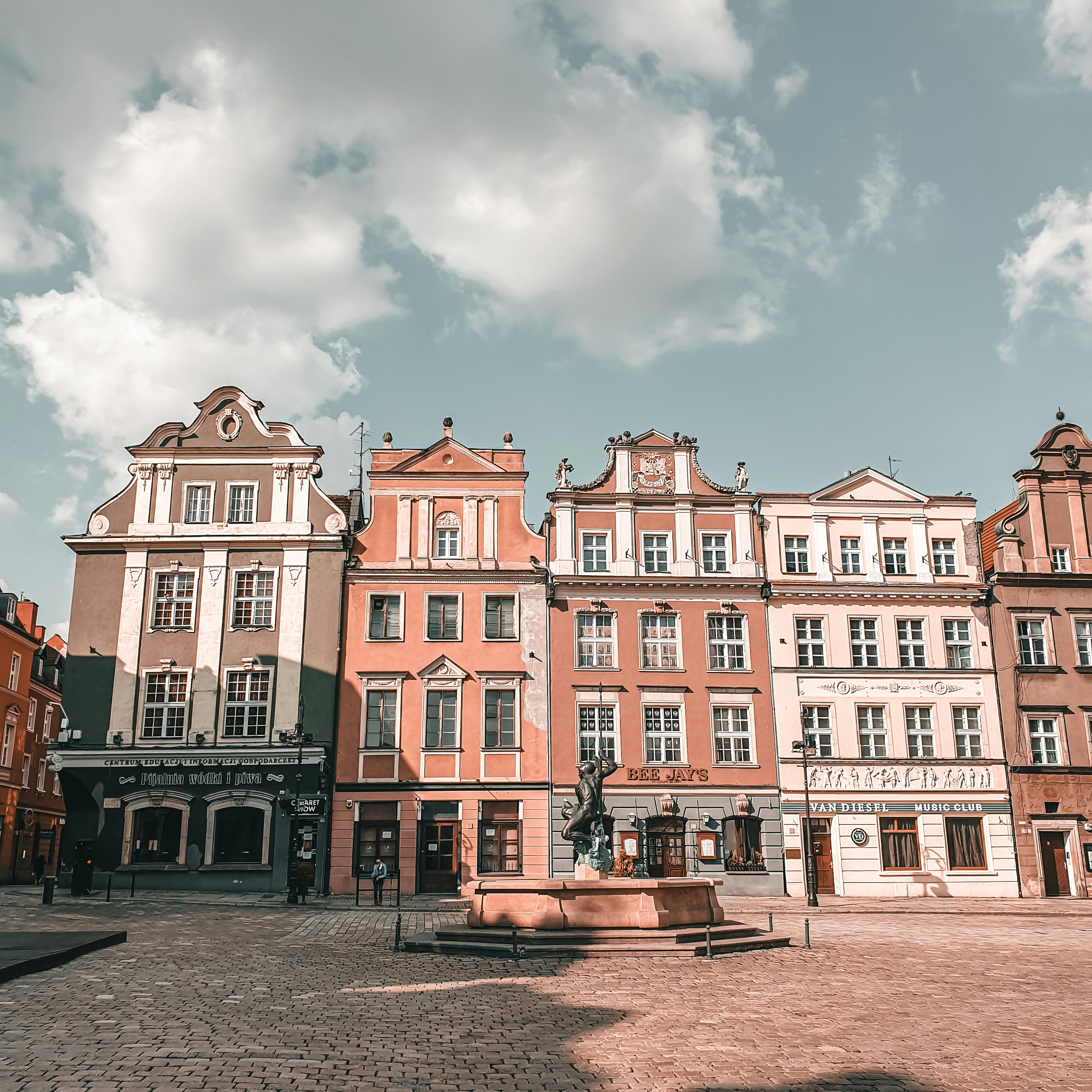 Edificio de hormigón blanco y marrón bajo el cielo nublado durante el día