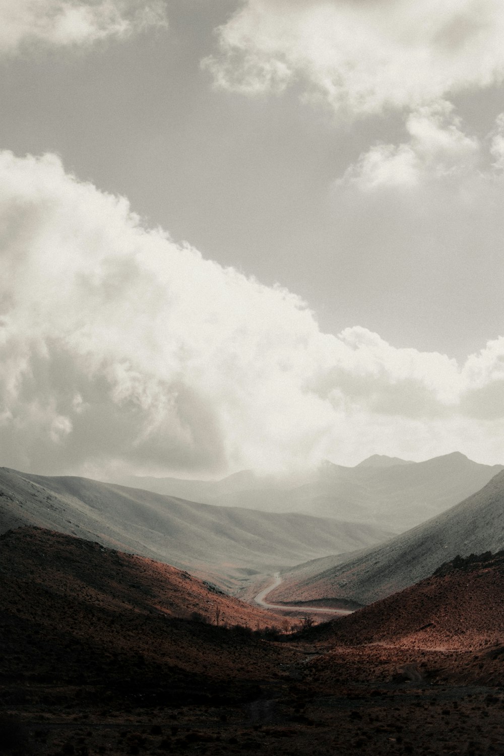 brown and green mountains under white clouds