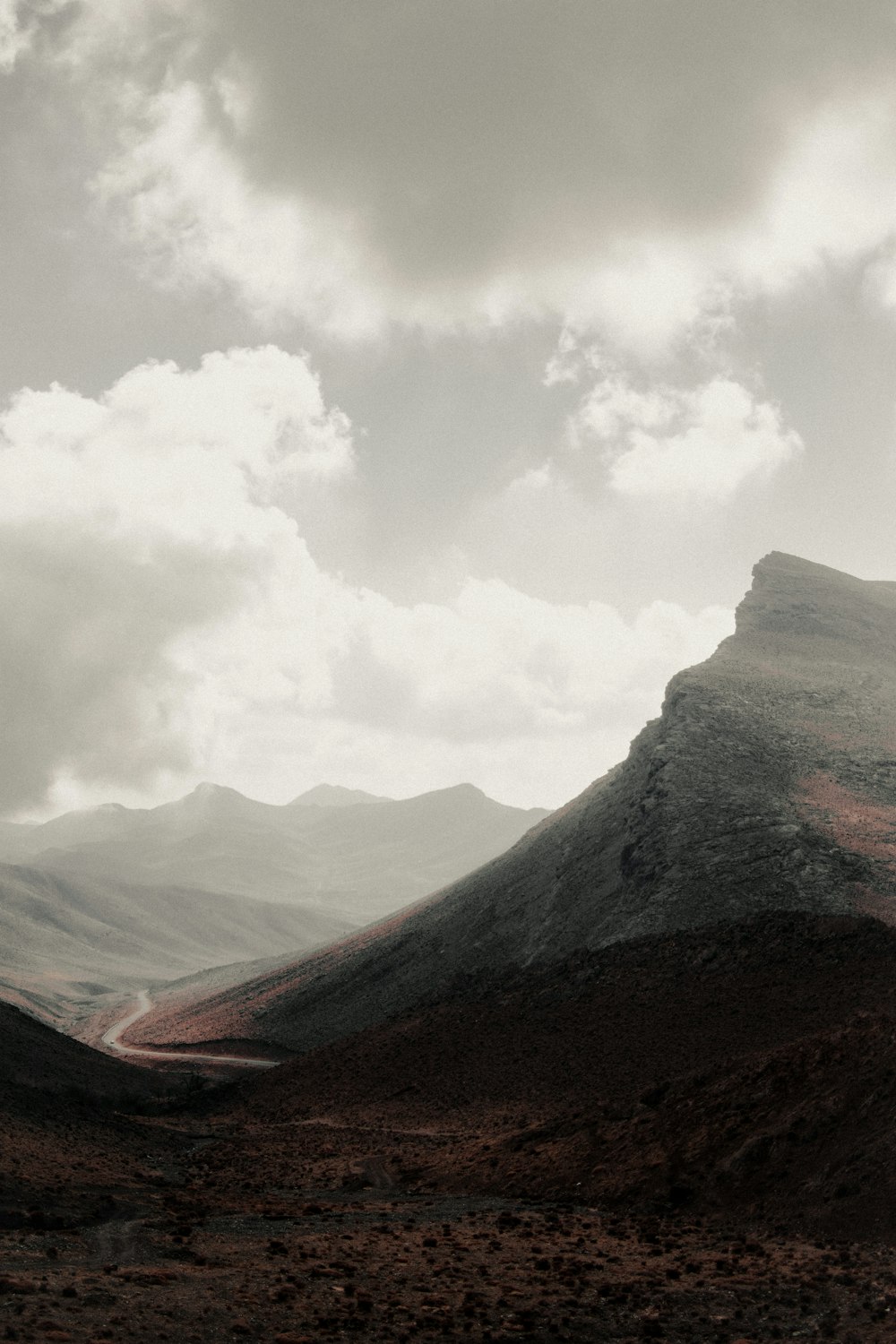 brown and green mountains under white clouds during daytime