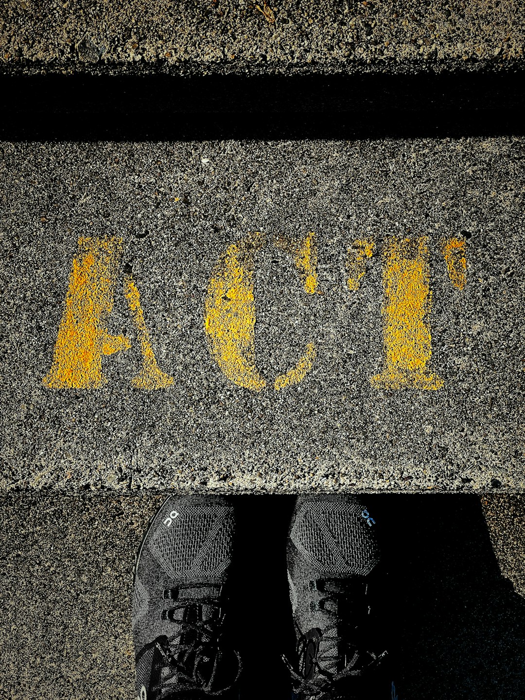 person wearing black shoes standing on black and yellow star print concrete floor