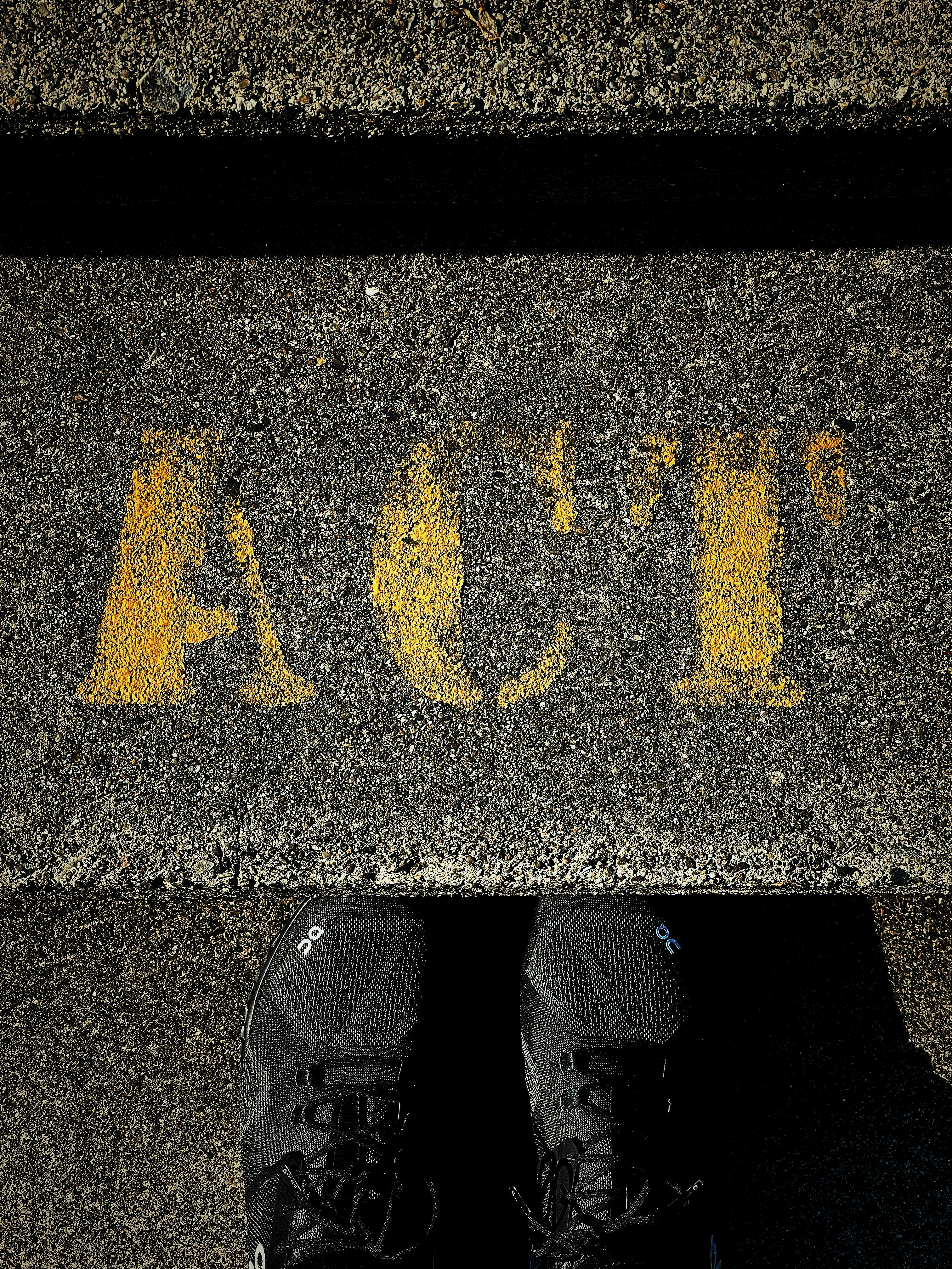 person wearing black shoes standing on black and yellow star print concrete floor