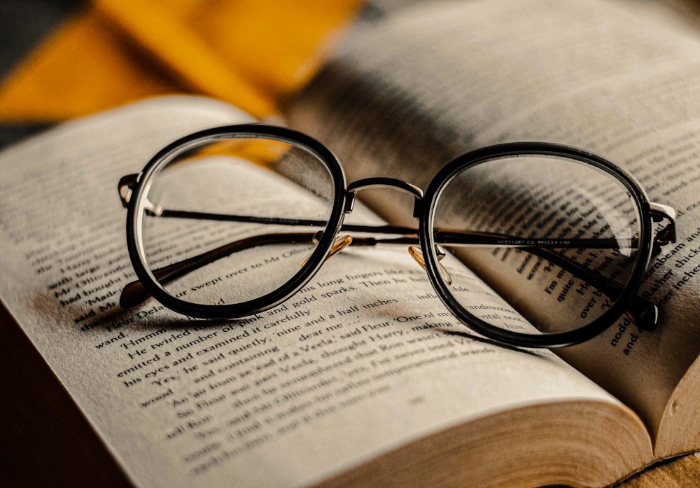 gafas de montura negra en la página del libro