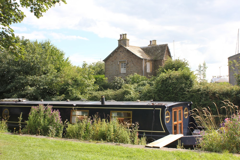 brown and black train near brown brick house during daytime