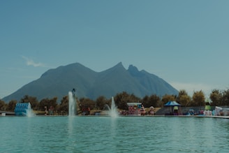 people in boat on water near mountain during daytime