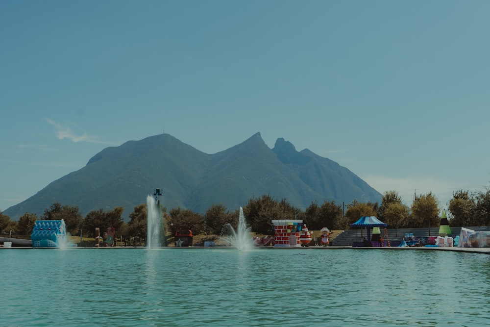 Personas en bote en el agua cerca de la montaña durante el día