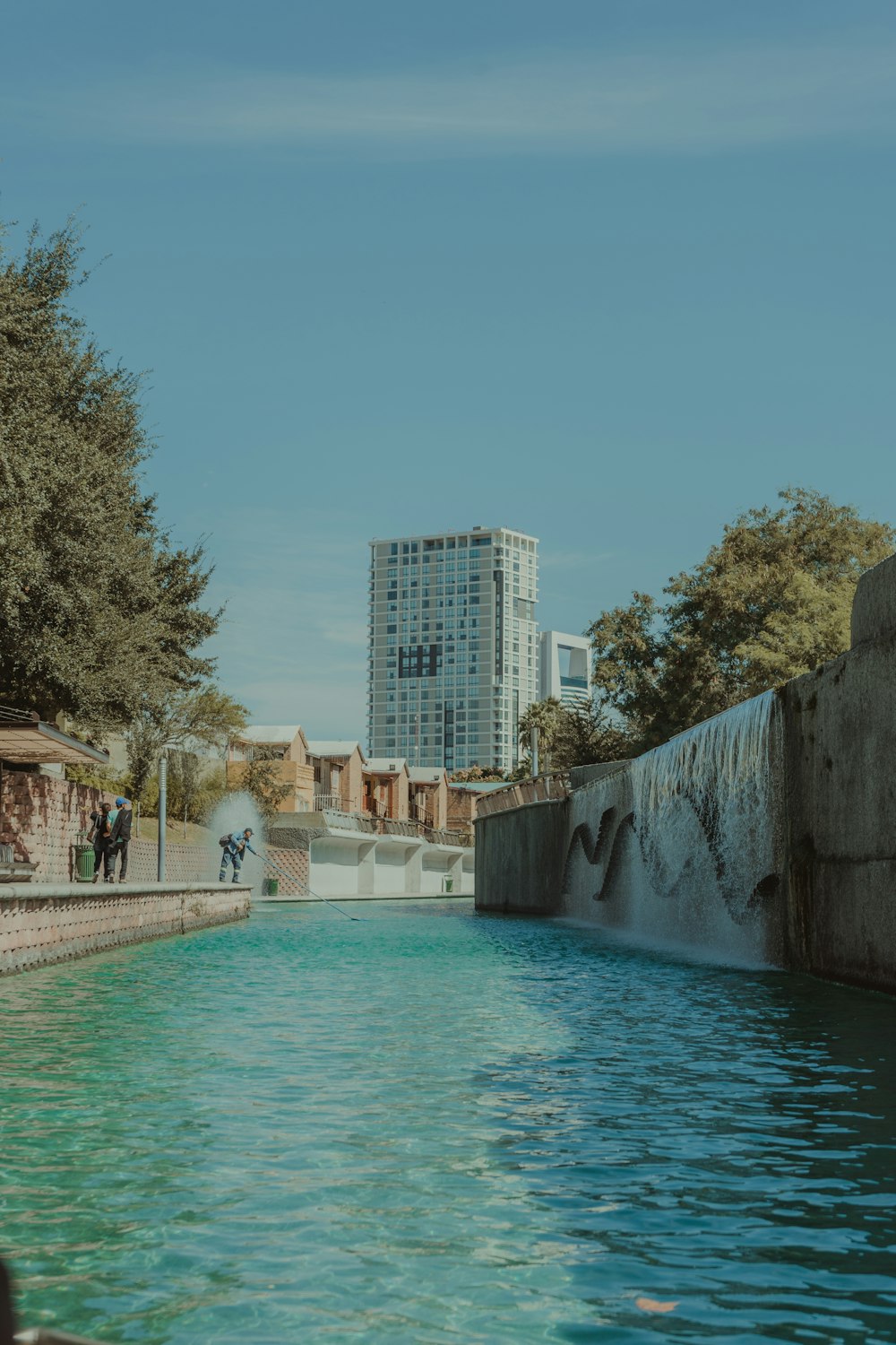 Menschen, die tagsüber auf dem Bürgersteig in der Nähe des Schwimmbades spazieren gehen