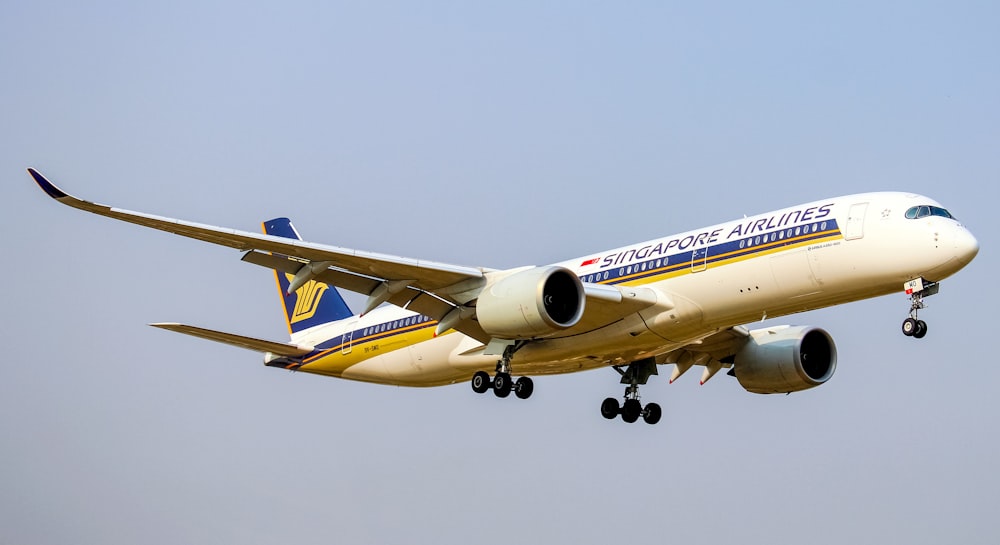 white and blue passenger plane in mid air during daytime