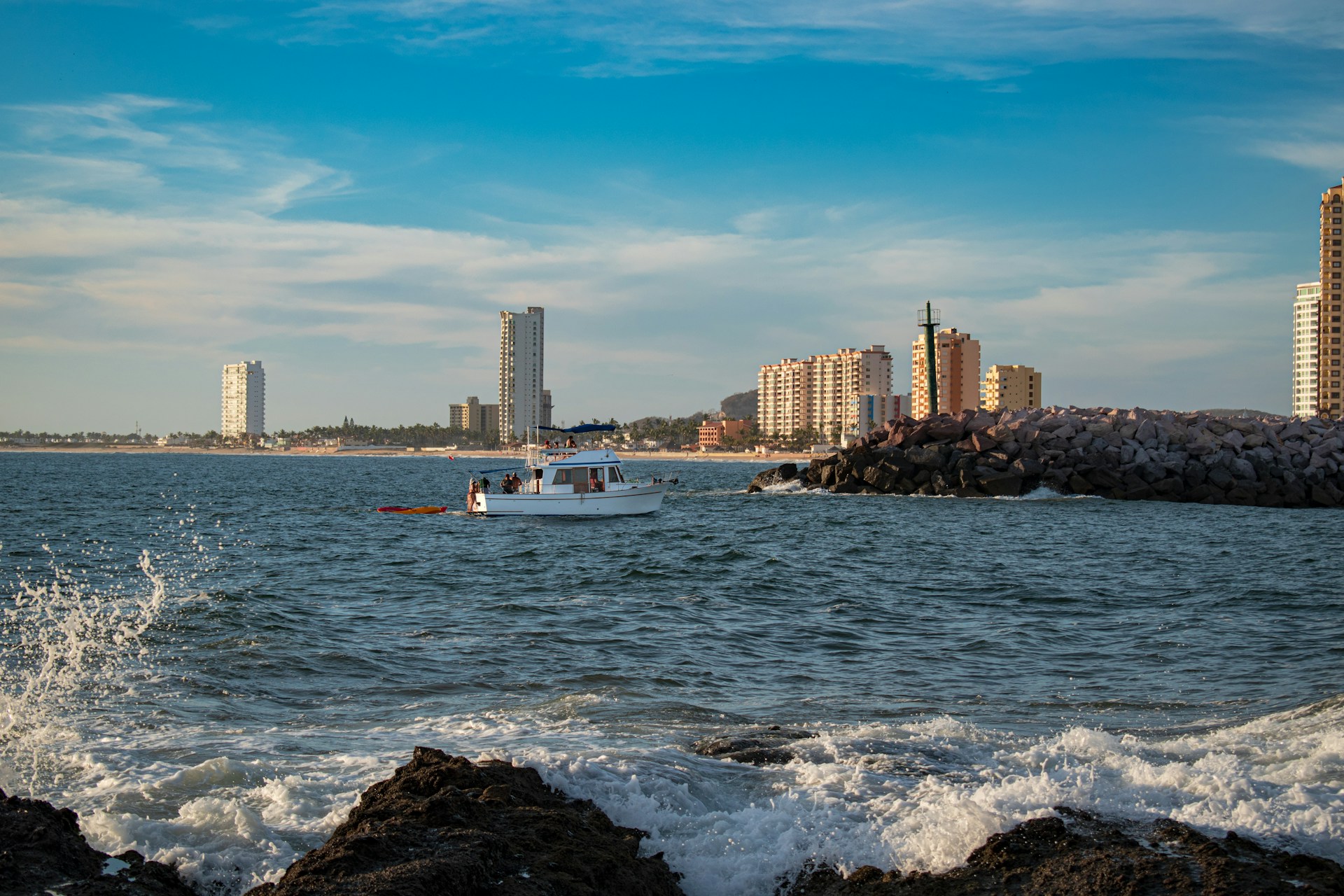 white boat on sea near city buildings during daytime