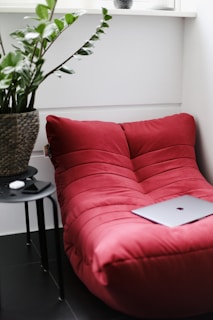 silver macbook on red couch