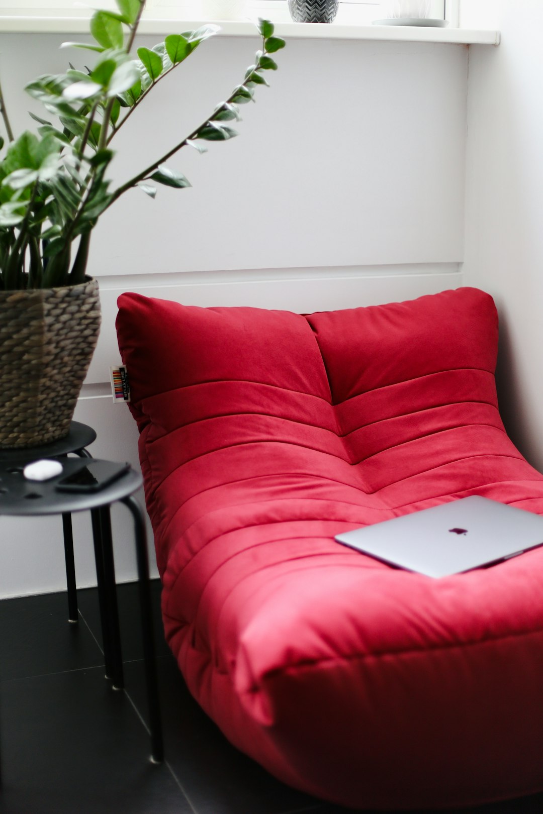 silver macbook on red couch