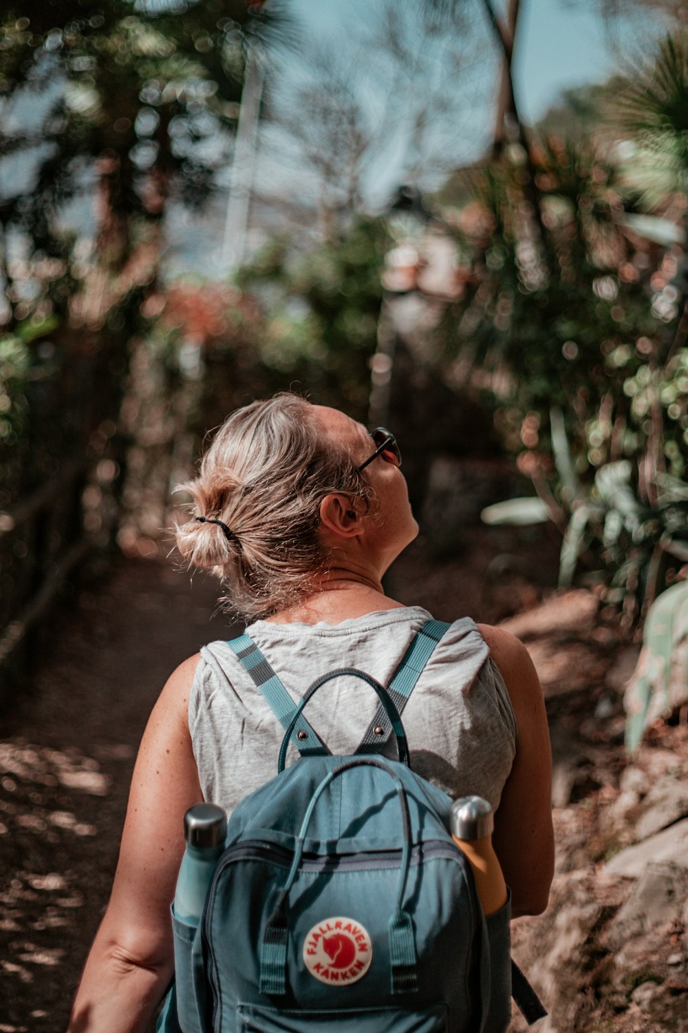 woman in teal tank top wearing black sunglasses