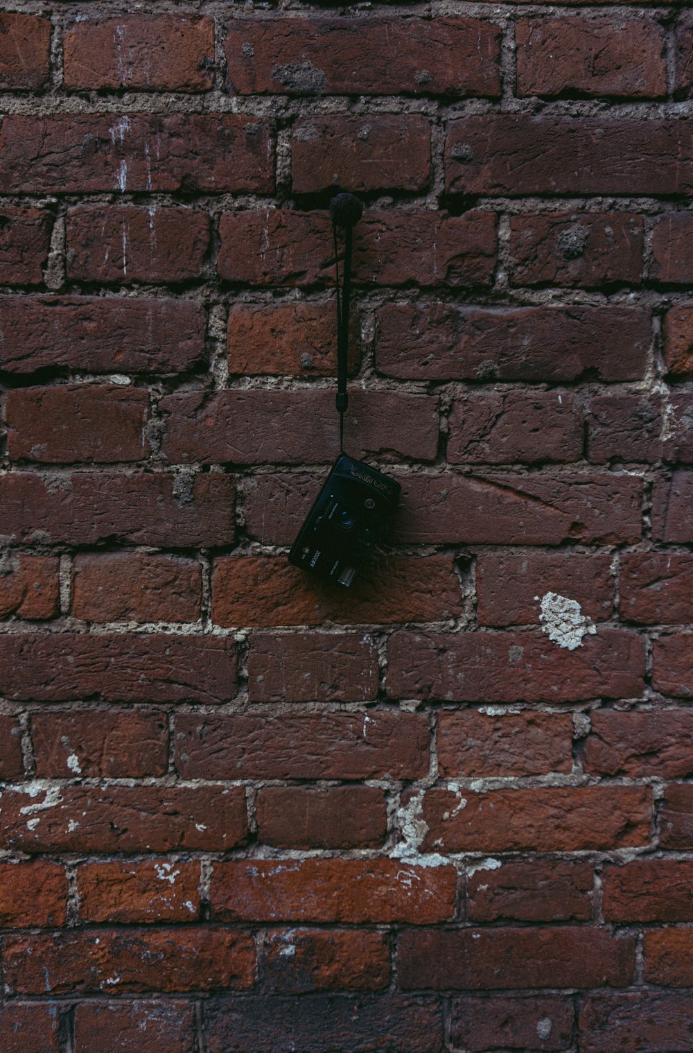 black metal tool on red brick wall