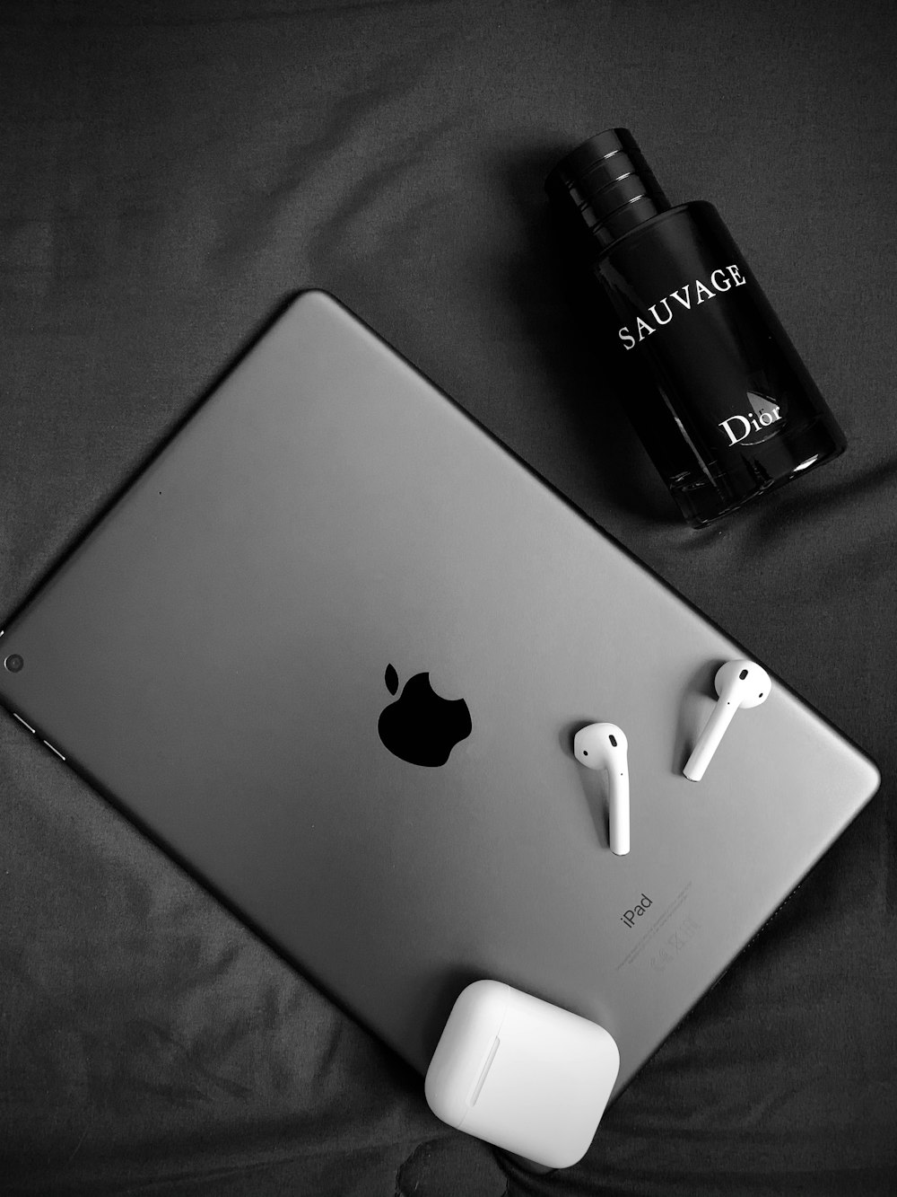 silver macbook beside black bottle