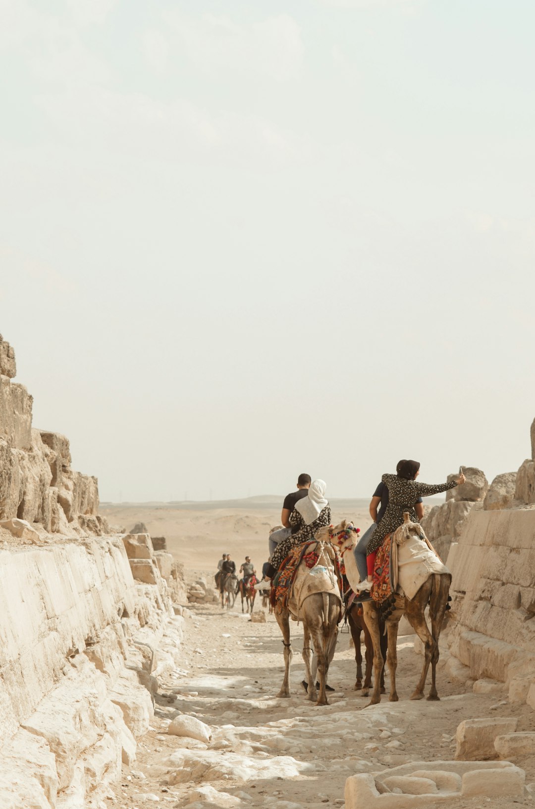 people riding horses on brown rocky mountain during daytime