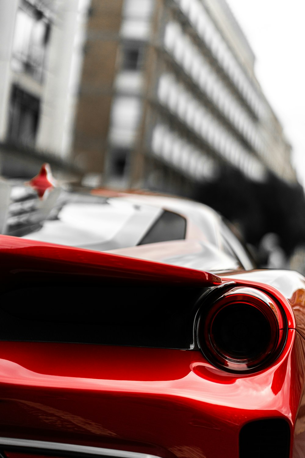 red car in front of white building