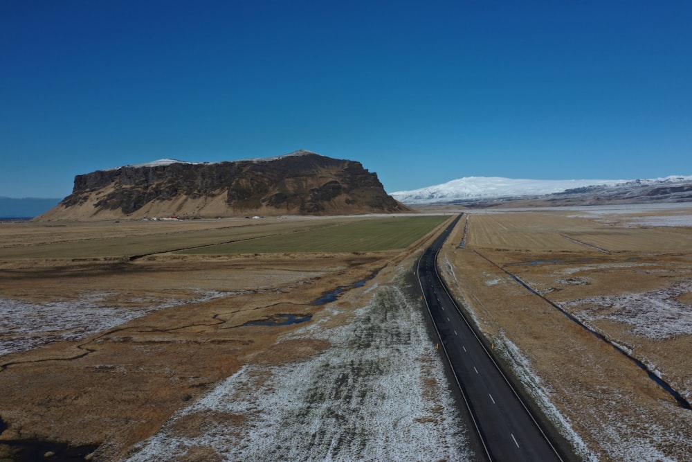 Binario ferroviario nero vicino al campo marrone sotto il cielo blu durante il giorno