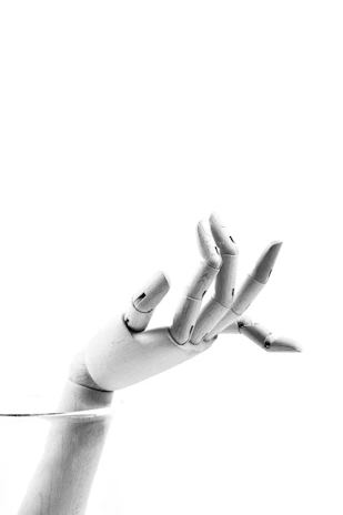 A sleek prosthetic arm displayed on a minimalist white stand against a deep purple backdrop.