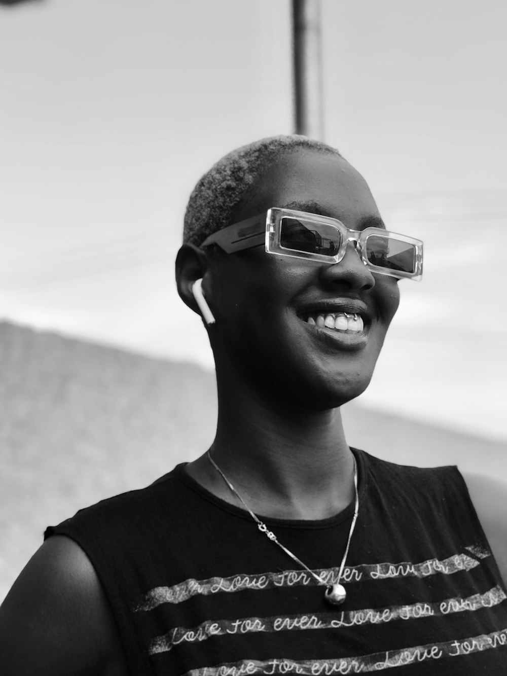 grayscale photo of woman in tank top wearing sunglasses