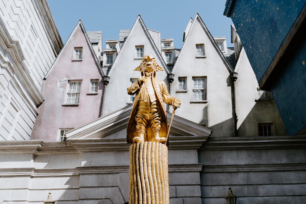 Estatua de oro cerca de un edificio de hormigón blanco durante el día