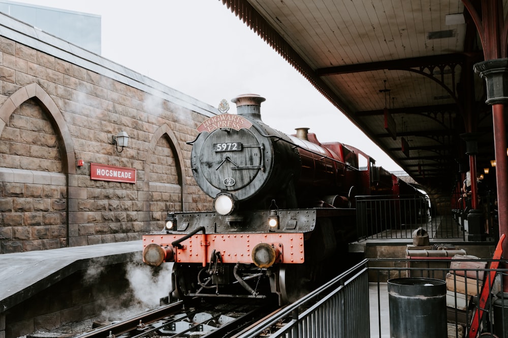 black and red train on rail tracks during daytime