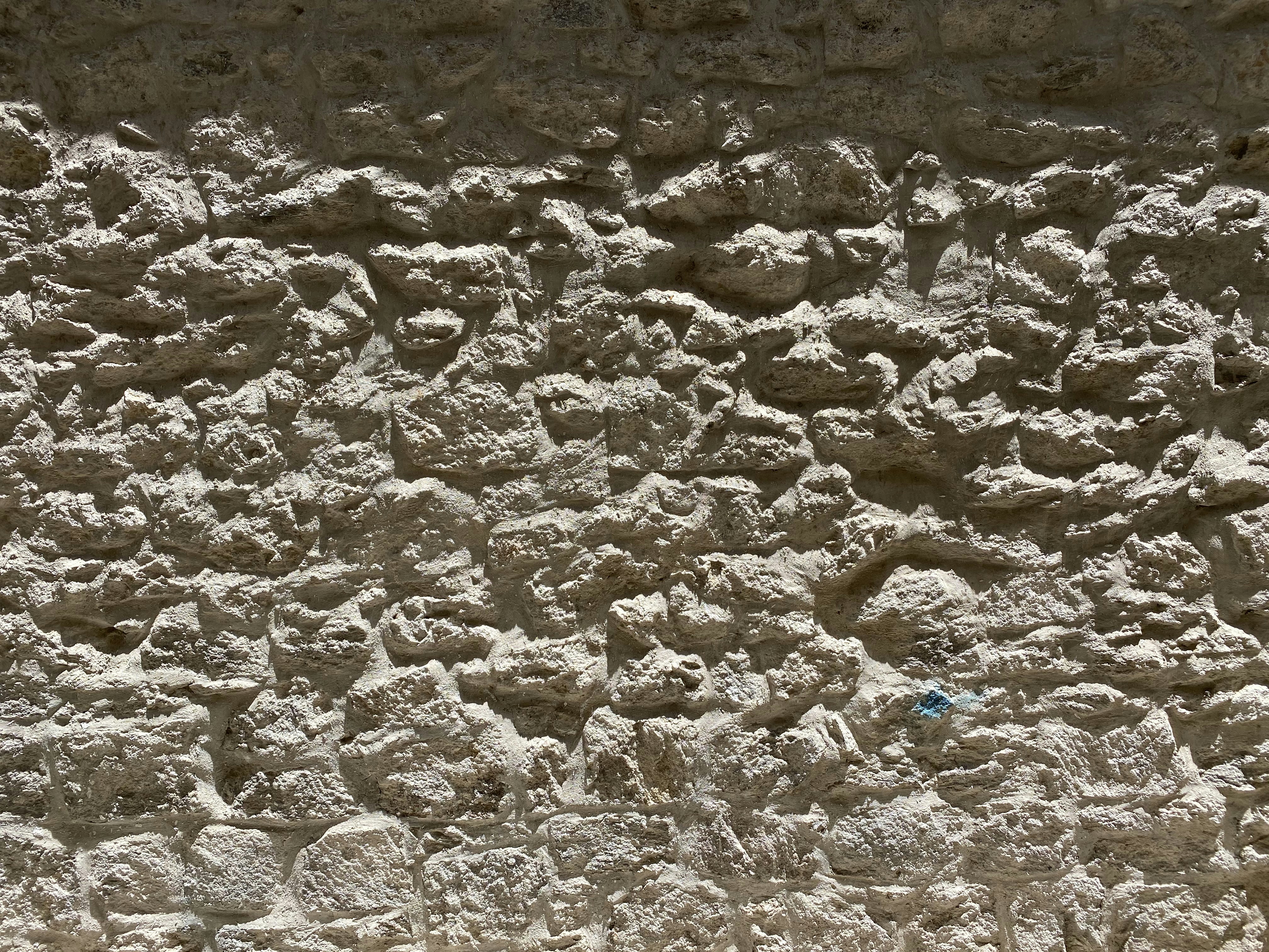 Traditional stone wall construction, natural stone texture, rustic aesthetic, outdoor daylight