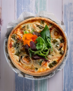pizza with green leaf vegetable on white ceramic plate