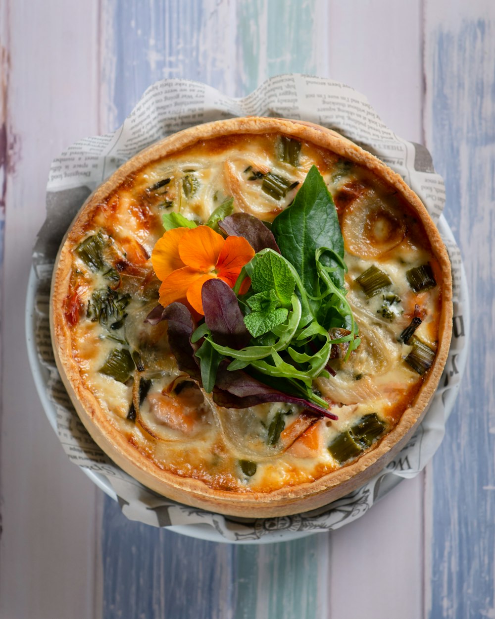 pizza with green leaf vegetable on white ceramic plate