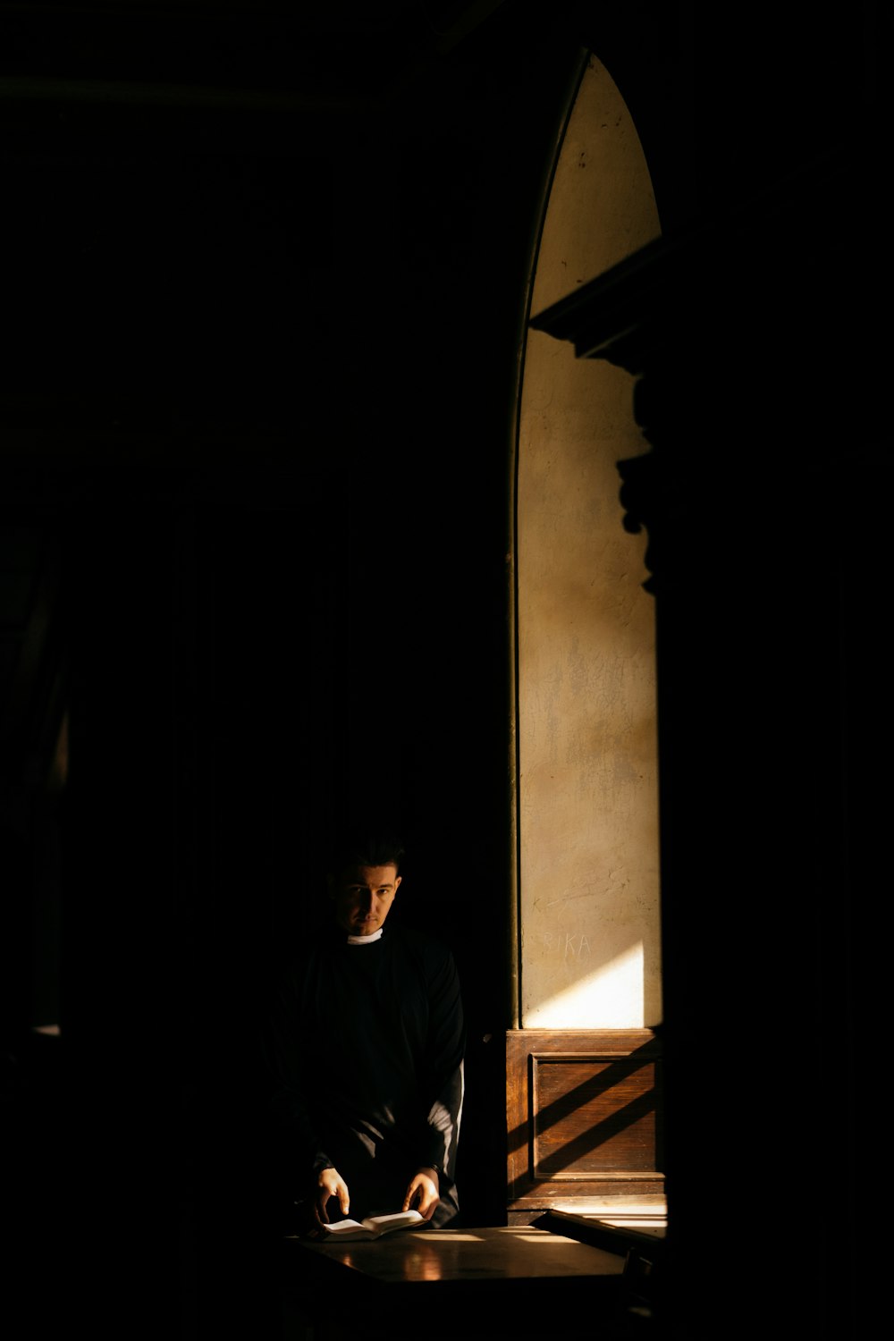 man in black shirt standing near doorway