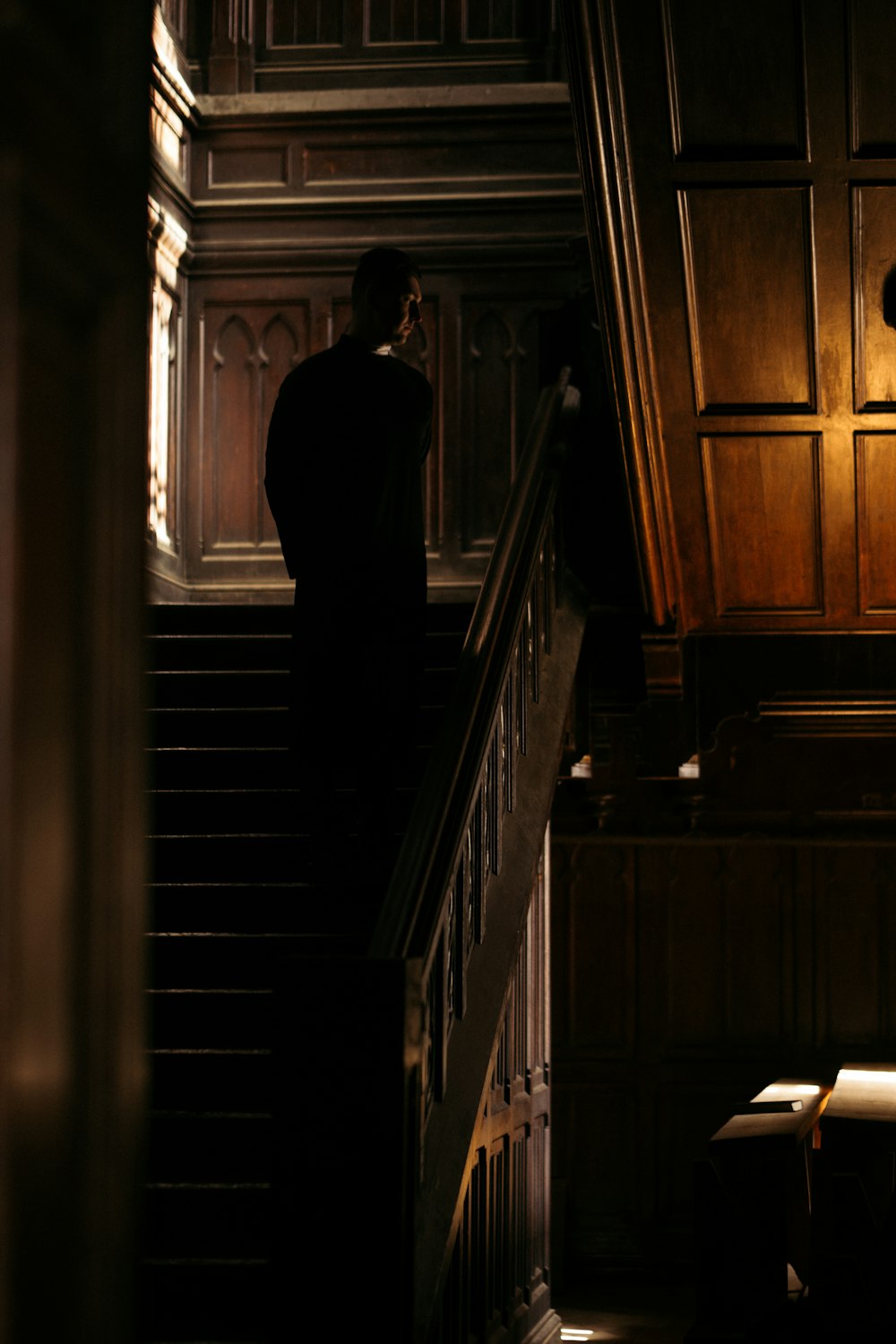 man in black suit standing on staircase