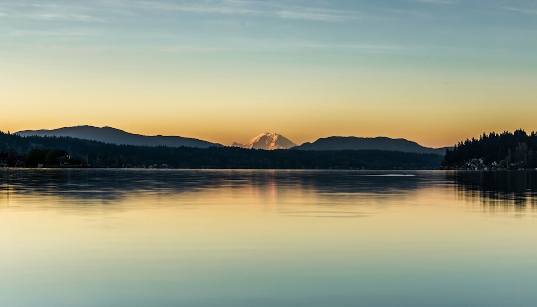 silhouette of mountain near body of water during daytime