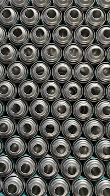 Close-up of shiny aluminum cans stacked neatly in a recycling facility