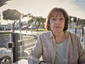 woman in white jacket sitting on bench during daytime