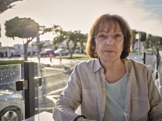 woman in white jacket sitting on bench during daytime