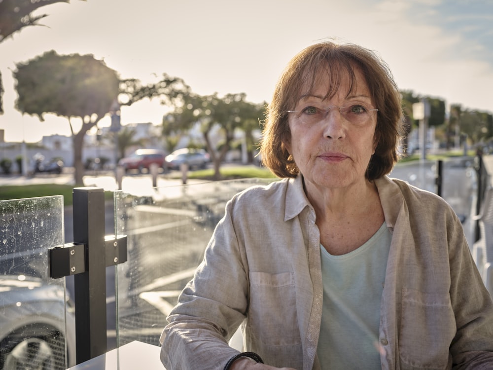 woman in white jacket sitting on bench during daytime