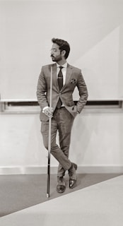 man in brown suit holding walking stick