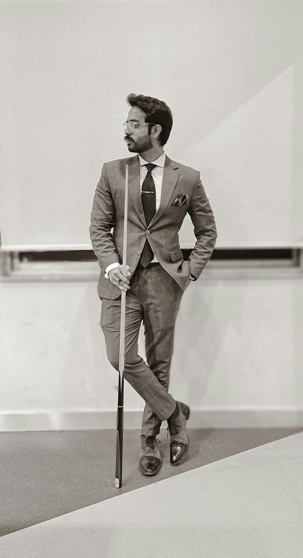 man in brown suit holding walking stick