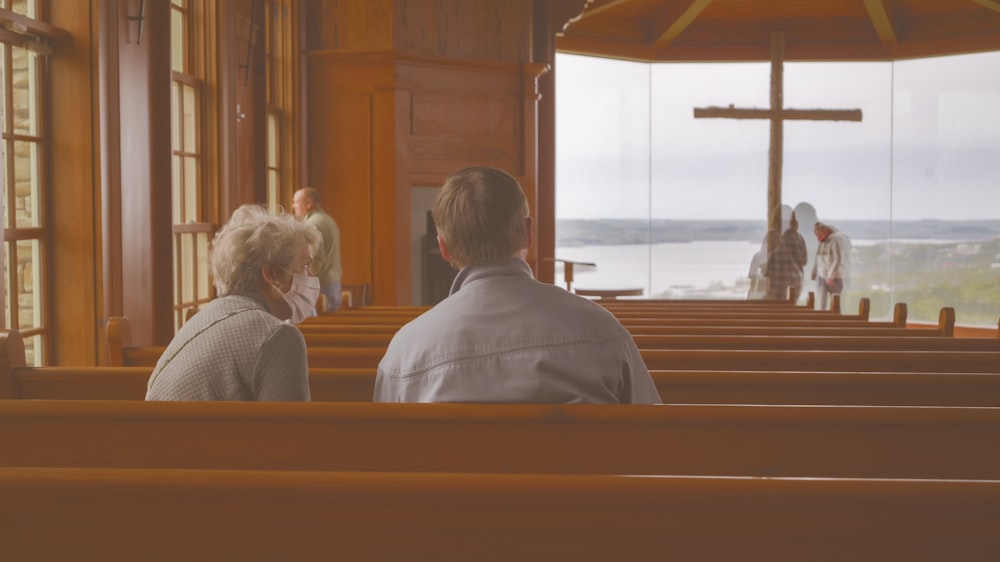 personnes assises sur un banc à l’intérieur d’un bâtiment