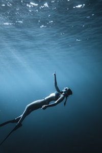 woman in black bikini swimming in the sea