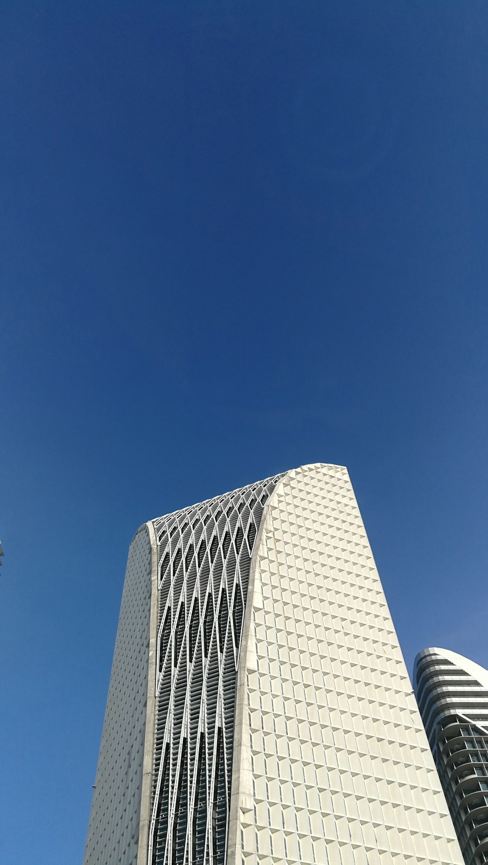 낮에는 푸른 하늘 아래 하얀 콘크리트 건물