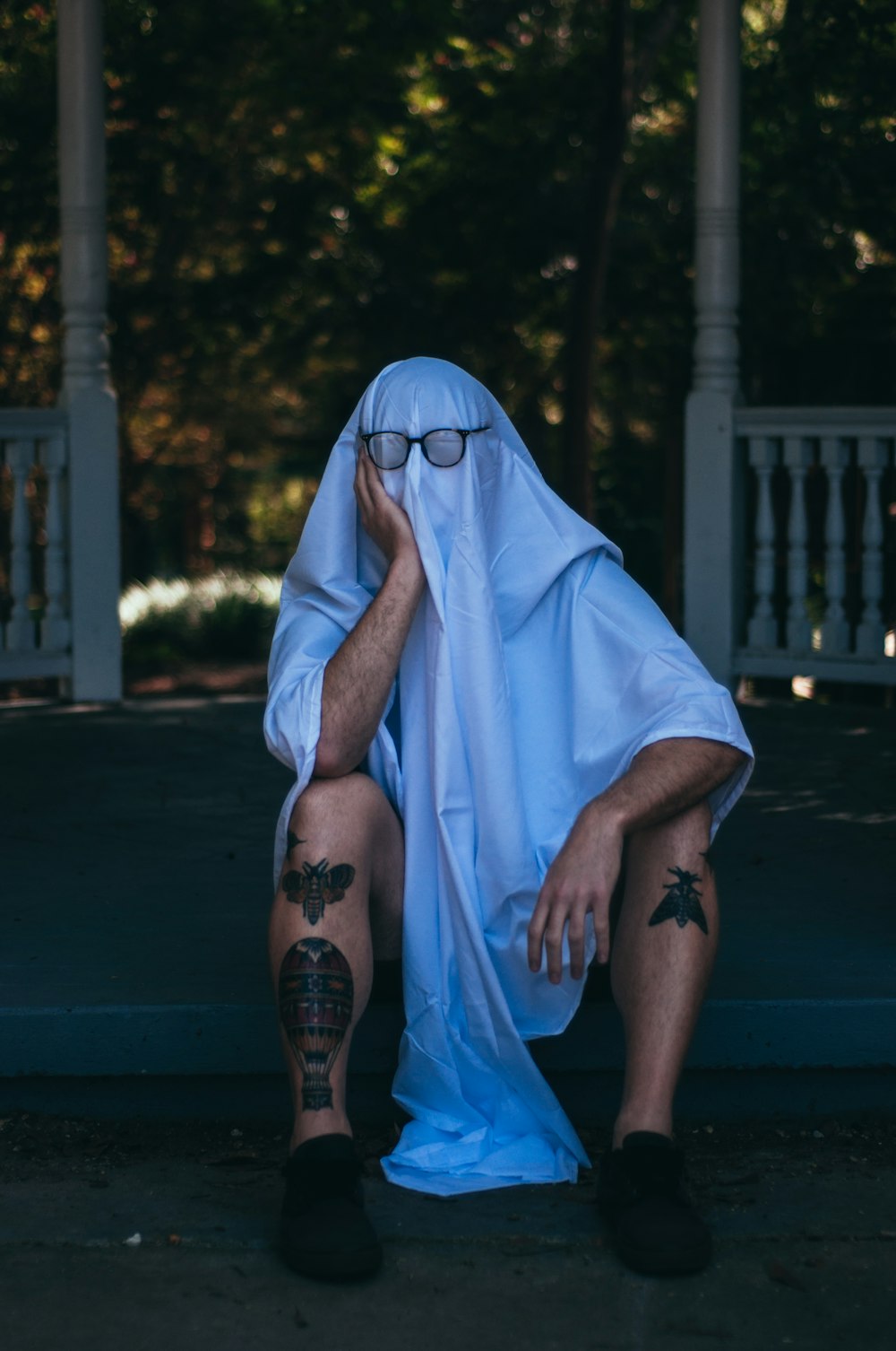 a man in a ghost costume sitting on the ground