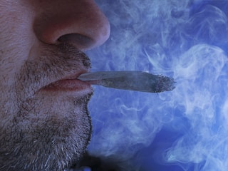 Close-up of a smoker using a safer nicotine filtration device.
