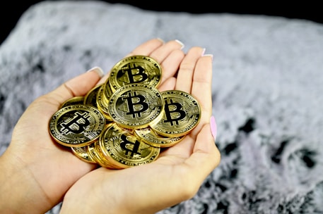 Hands holding golden coins with a soft glowing cross in the background.