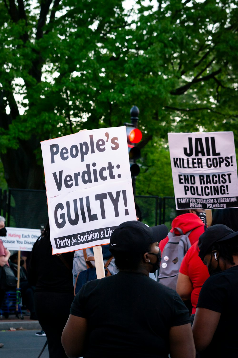 people holding white and black signage during daytime