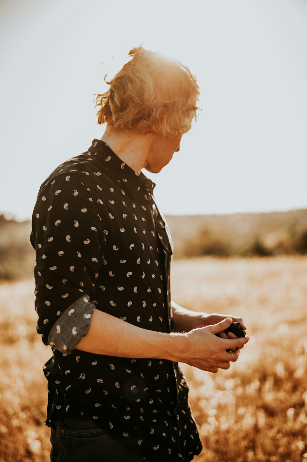 woman in black and white polka dot shirt holding black smartphone