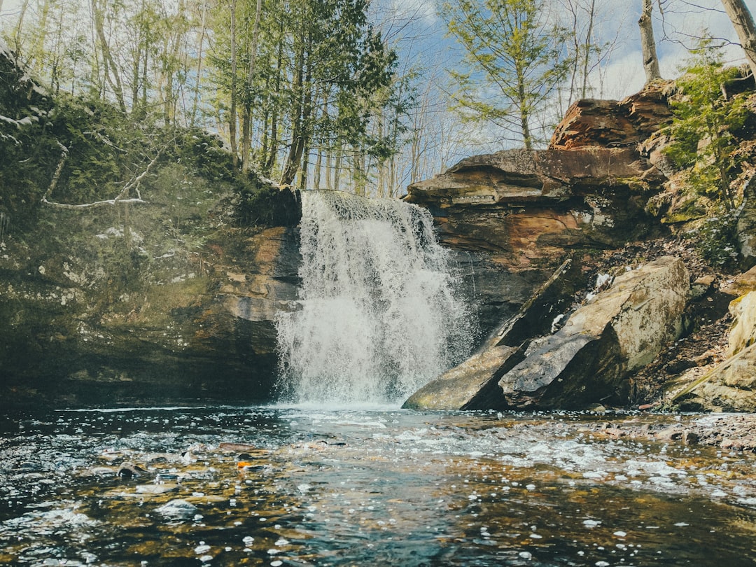 water falls on brown rocky mountain during daytime