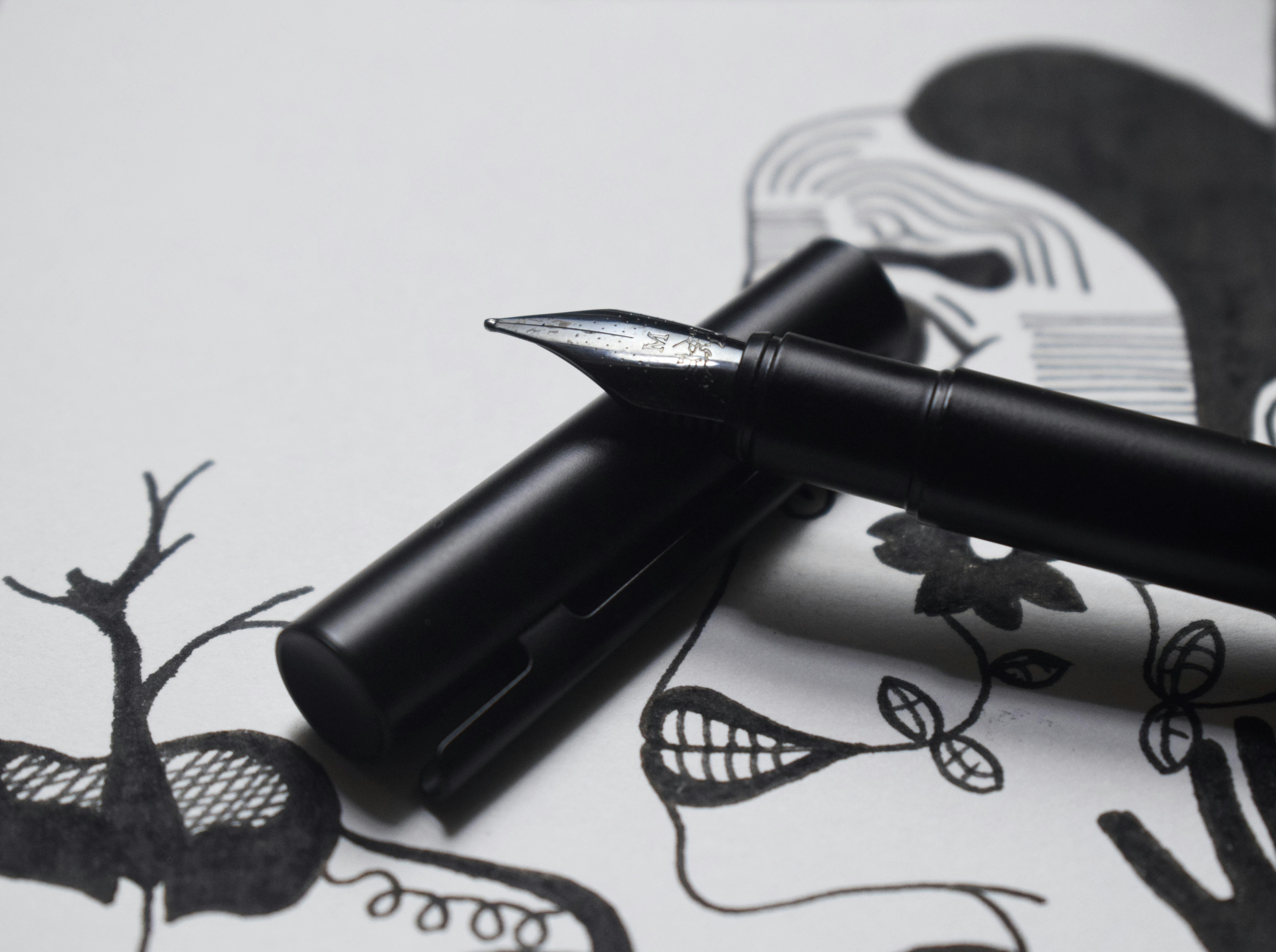 Pulpen Pilot G2 hitam di atas kertas putih