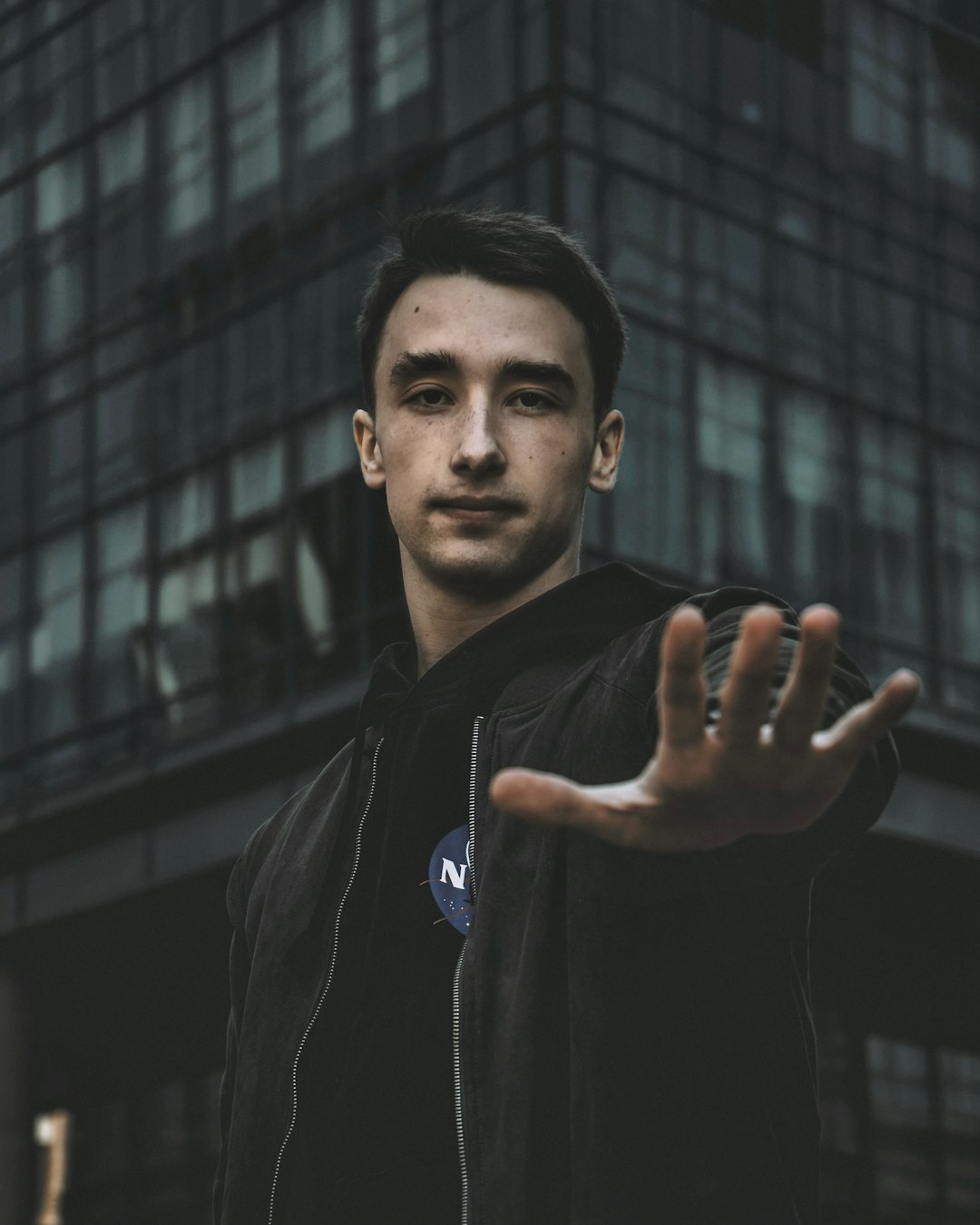 man in black jacket standing near building during daytime