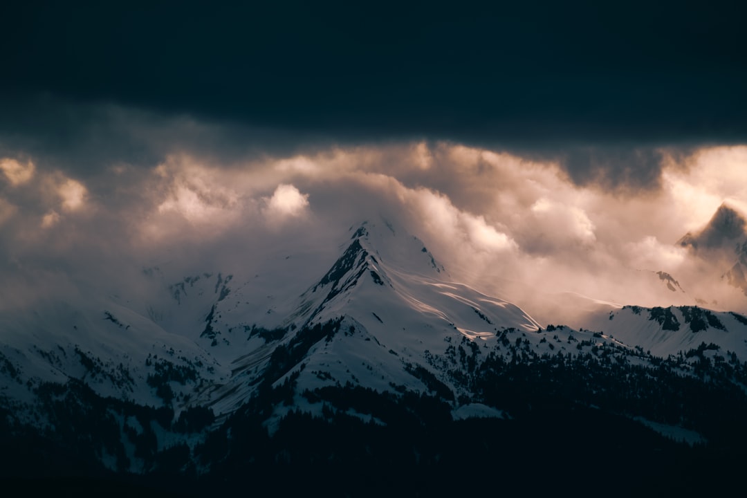 snow covered mountain under cloudy sky during daytime